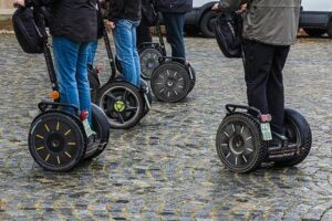 Multiple people riding segways on cobblestone