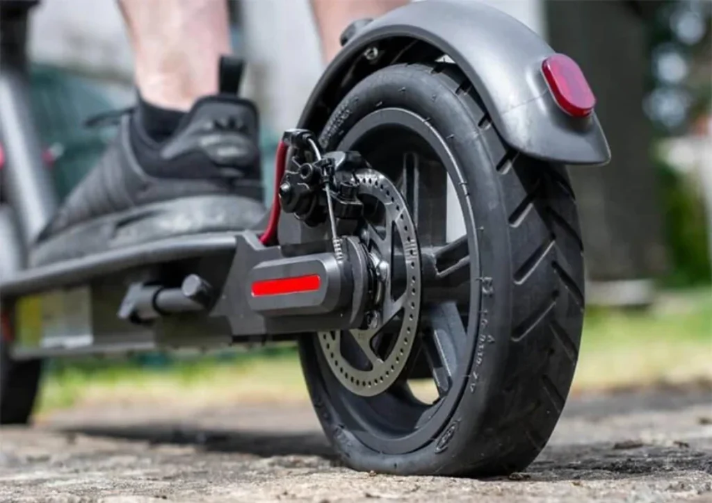 A deflated rear pneumatic tire on an electric scooter