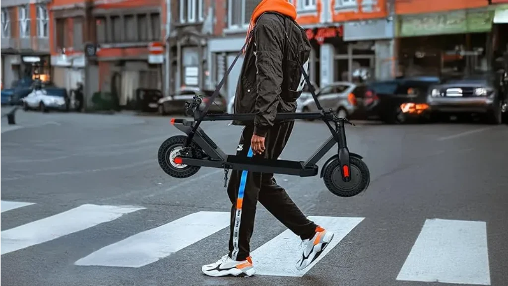 Man carrying electric scooter using shoulder strap