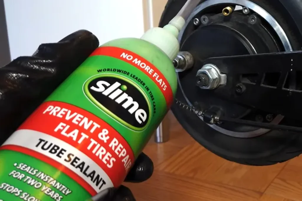 Slime no more flats being applied into an electric scooter rear tire