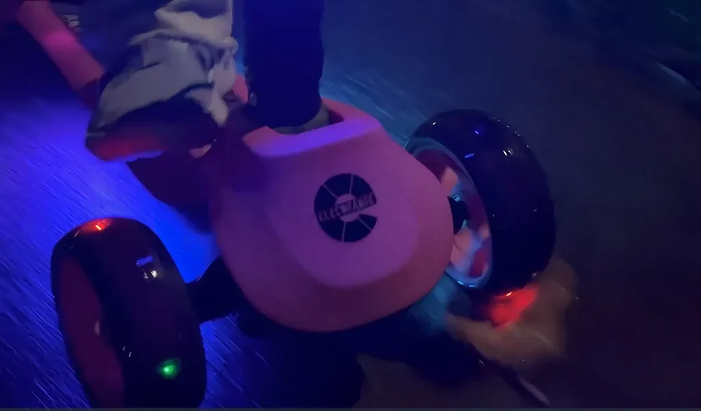 The LED wheels and lights of the T500 kids scooter lighting up in the dark
